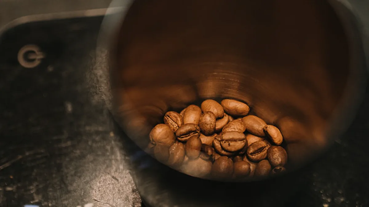 A digital kitchen scale displaying exact coffee bean grams next to a ceramic dripper