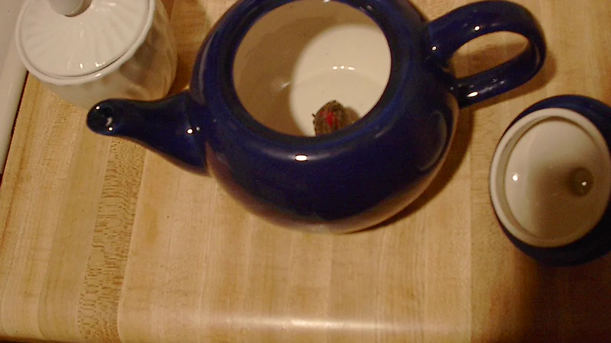 Dried whole leaf sencha green tea spread evenly across a traditional bamboo tea brewing tray