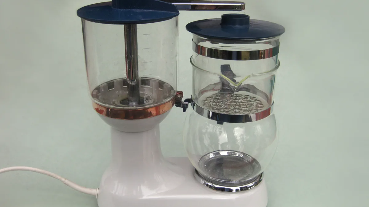 A modern automatic electric drip coffee machine brewing fresh dark coffee into a glass carafe