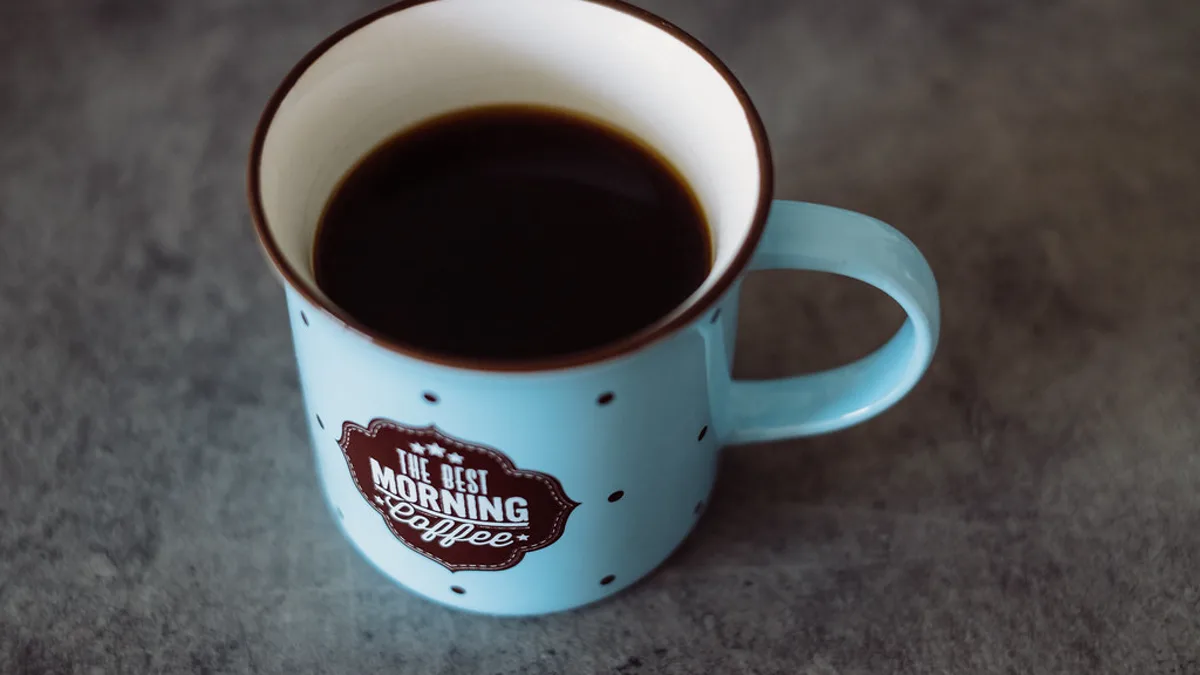 Two freshly prepared cups of specialty coffee resting side by side on a granite kitchen countertop
